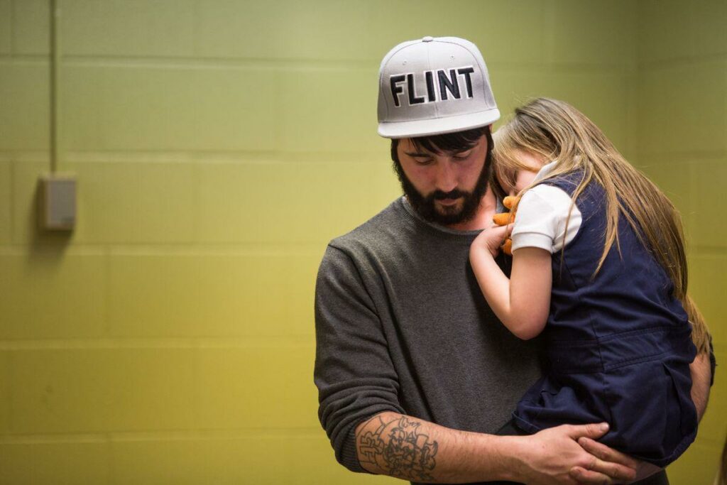 Flint water crisis. Man holding young girl.
